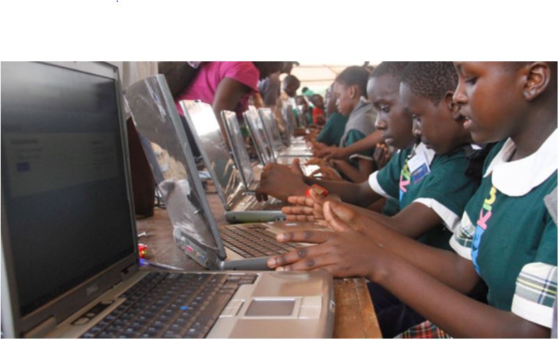 Students working on a shared laptop in a Ugandan classroom